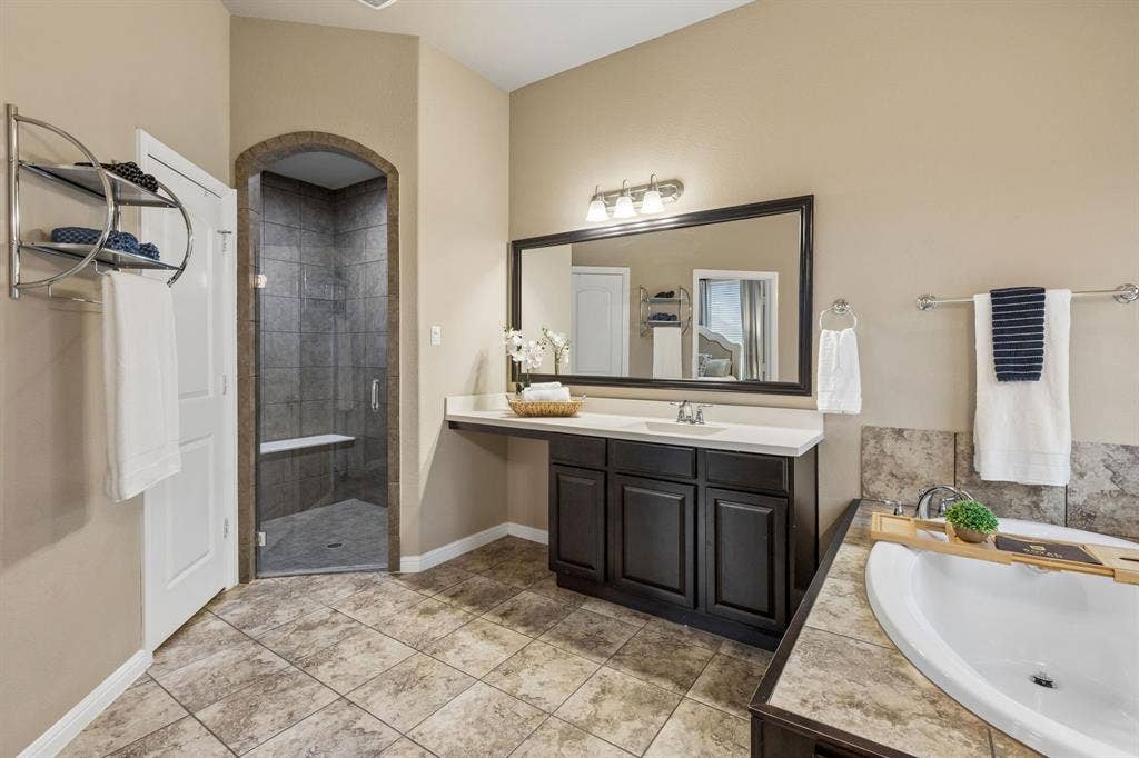 Another view of the primary bath highlights the spacious walk-in shower and its beautiful finishes.