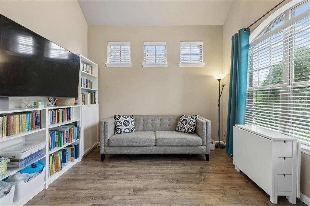 The spacious office features soaring 12-foot ceilings, durable LVP flooring, and a large window that fills the room with beautiful natural light.