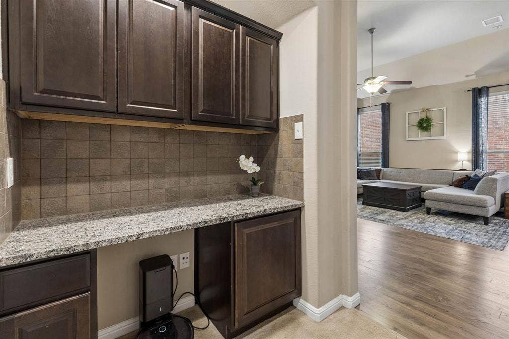 Built in desk area with granite countertops and stained wood cabinets.