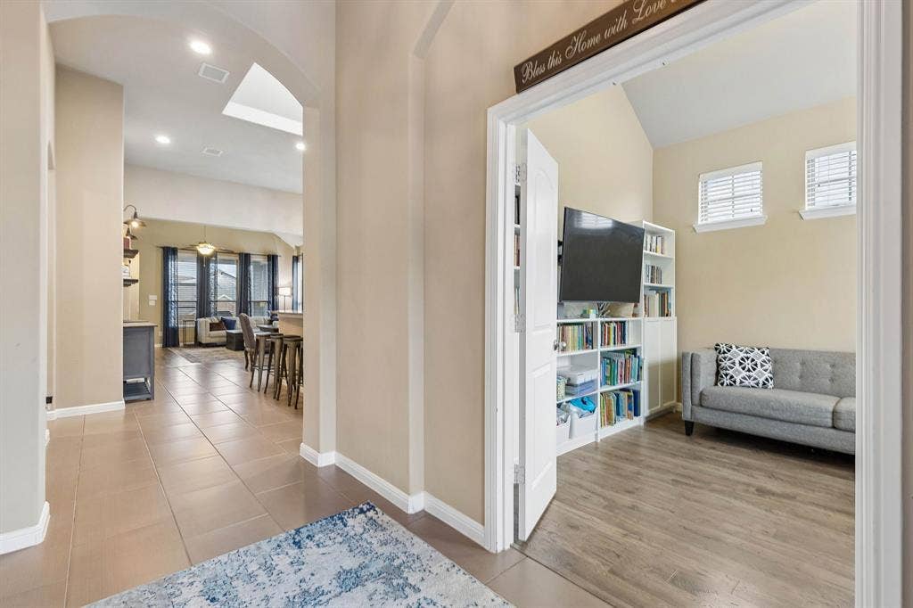 As you enter the home, you'll find the private office immediately to your right, featuring tile floors, a decorative light and elegant French doors that create a warm and inviting entrance.