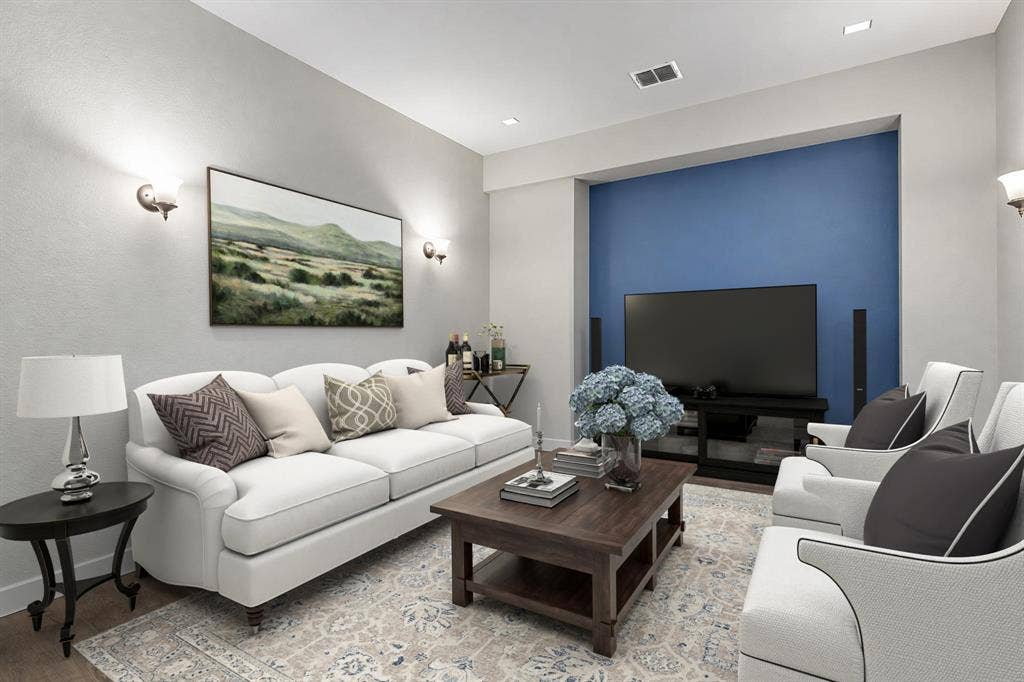 The media room features LVP flooring, stylish metallic wall sconces, and a dedicated wall niche ideal for a TV or projector screen. VIRTUALLY STAGED