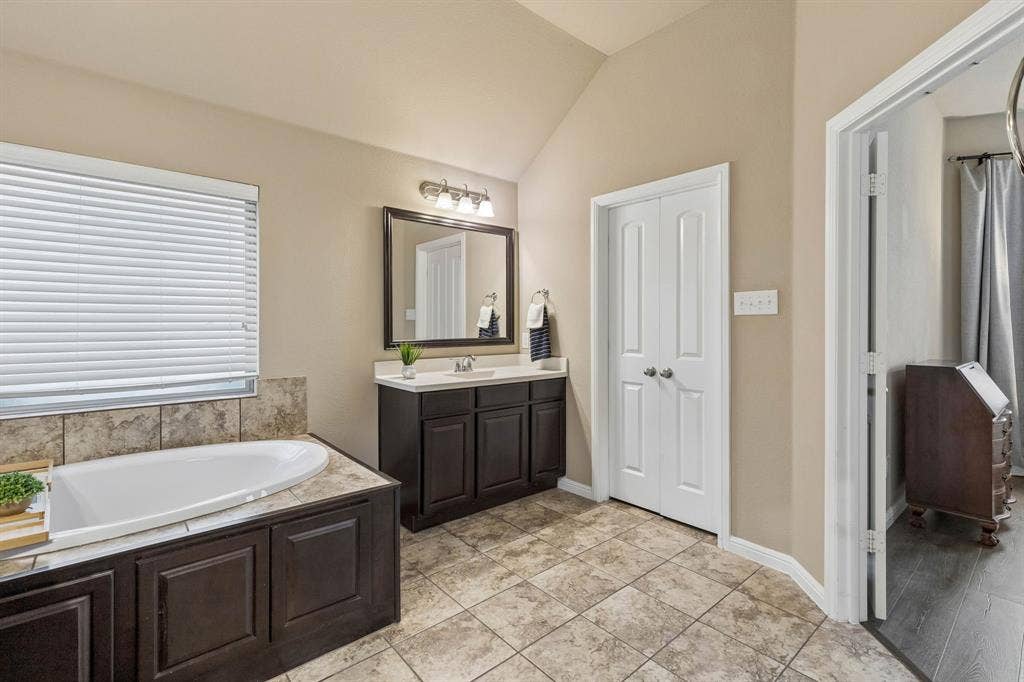 This view showcases the second vanity, additional storage, and convenient access to the spacious walk-in closet.