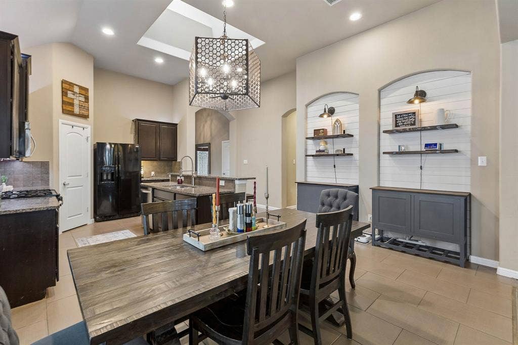 Another view of the dining area showcases the beautiful built-in wall niches with white shiplap accents, decorative shelving, and stylish lighting.