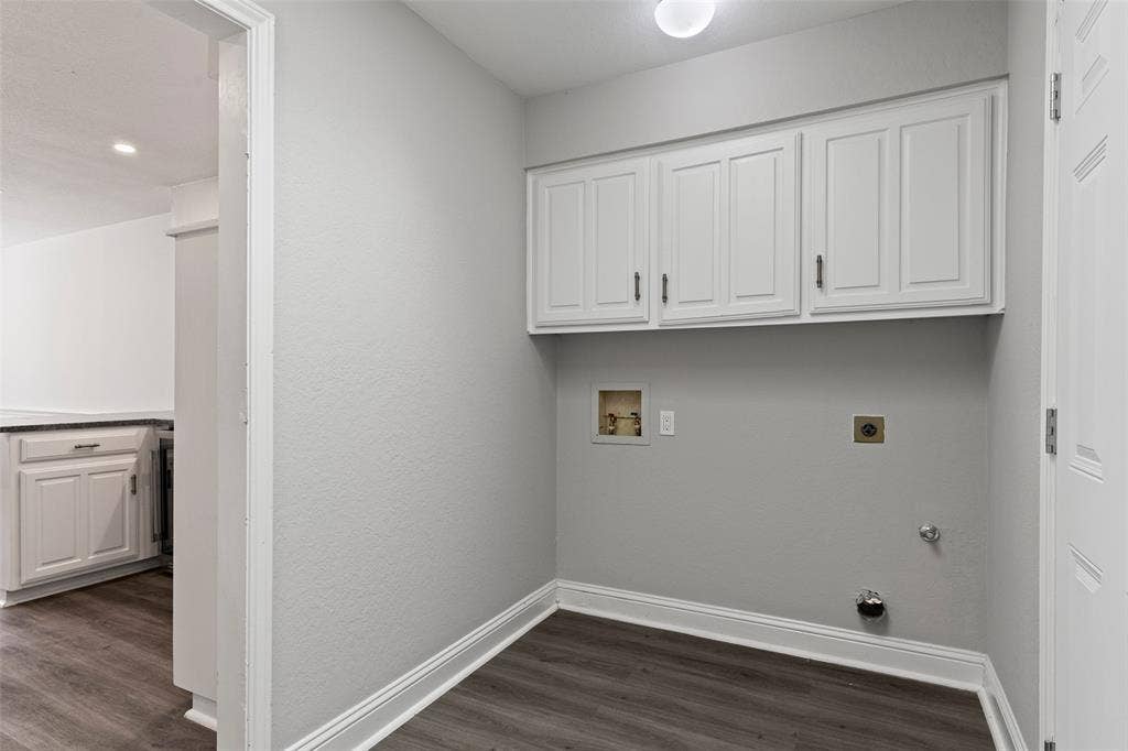 4128 Woodenrail Lane, Irving, TX 75061 Utility area featuring white built-in upper cabinetry, wood-finish flooring, and dedicated washer and dryer hookups