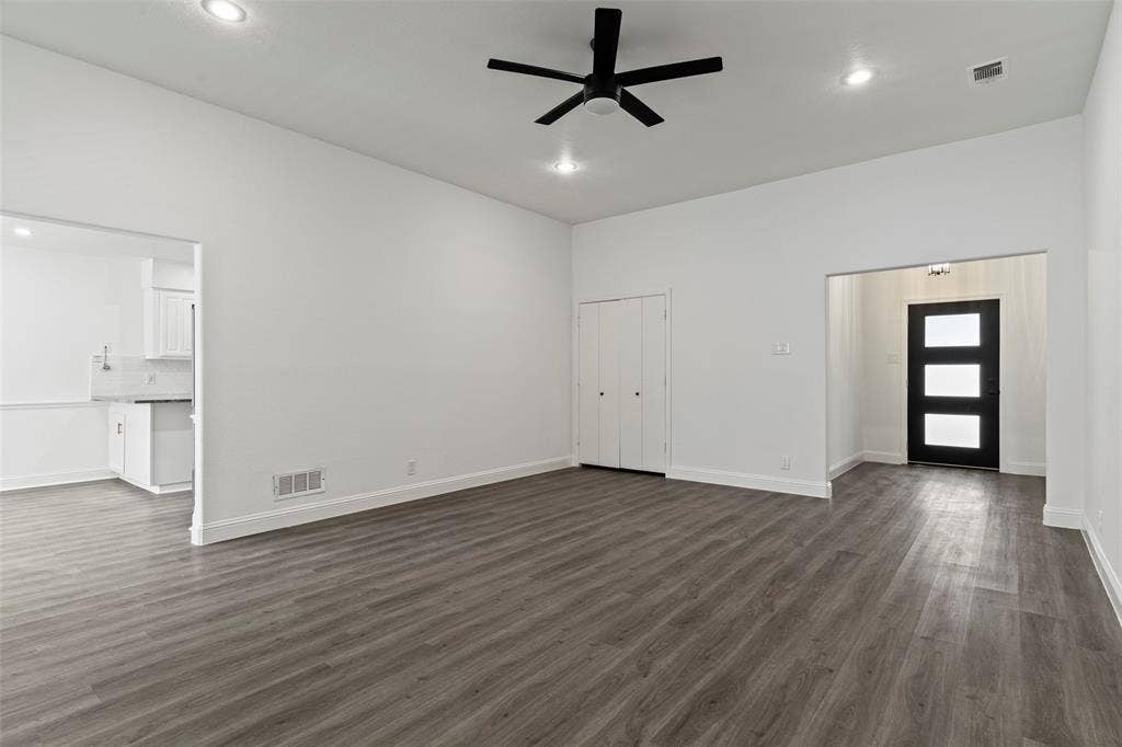 4128 Woodenrail Lane, Irving, TX 75061 High-ceilinged interior featuring wood-finish flooring, recessed lighting, a matte black ceiling fan, and an entry door with glass panels
