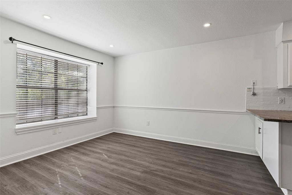 4128 Woodenrail Lane, Irving, TX 75061 Wood-finish flooring, recessed lighting, white chair rail molding, and a large window featuring horizontal blinds