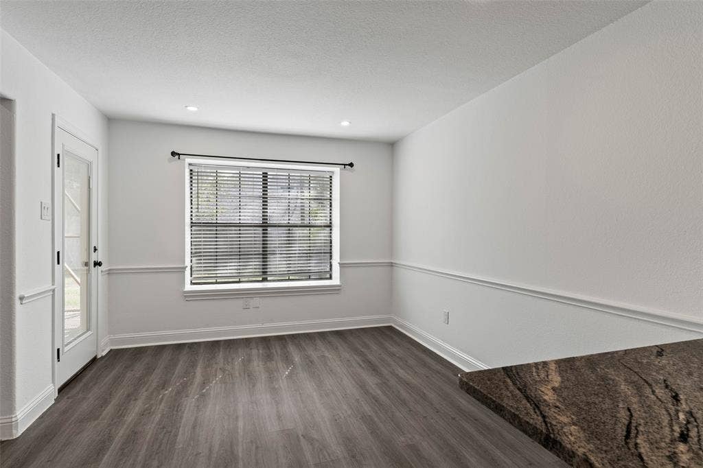 4128 Woodenrail Lane, Irving, TX 75061 Neutral wall paint featuring chair rail molding, wood-finish flooring, recessed lighting, and a window with horizontal blinds