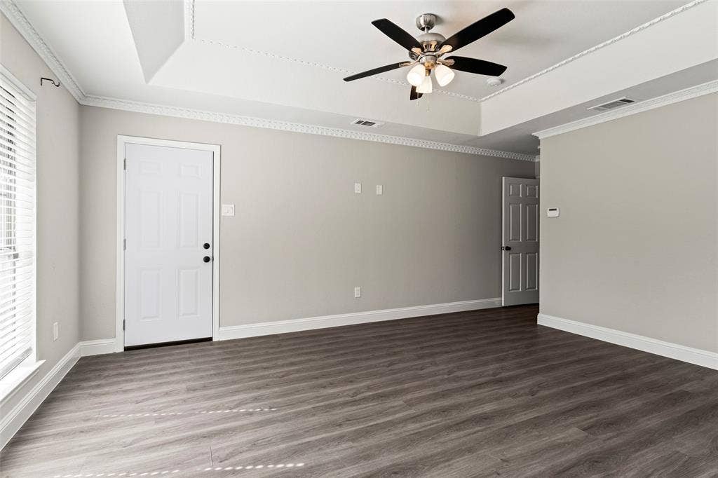4128 Woodenrail Lane, Irving, TX 75061 Tray ceiling with crown molding, wood-finish flooring, and a central ceiling fan with integrated lighting