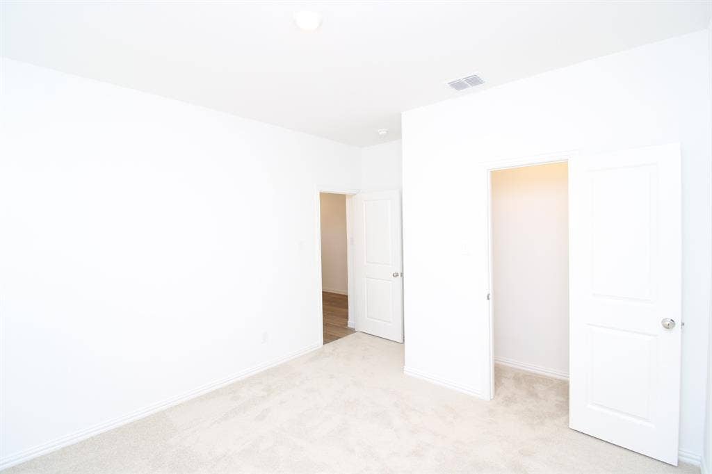 Neutral-toned carpeting, two-panel interior doors, and closet storage