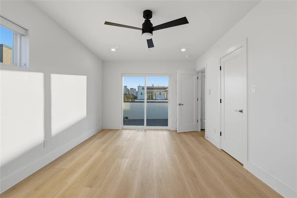 4319 San Jacinto Street, #101, Dallas, TX 75204 Wood-finish flooring, sliding glass door with access to a balcony, matte black ceiling fan, and recessed lighting