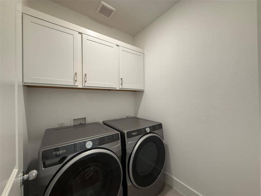Laundry area featuring white shaker-style wall-mounted cabinetry and metallic hardware