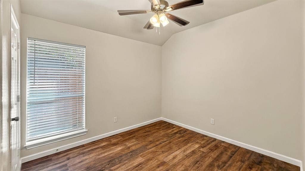 Wood-finish flooring, neutral wall tones, multi-light ceiling fan, and window fitted with horizontal blinds