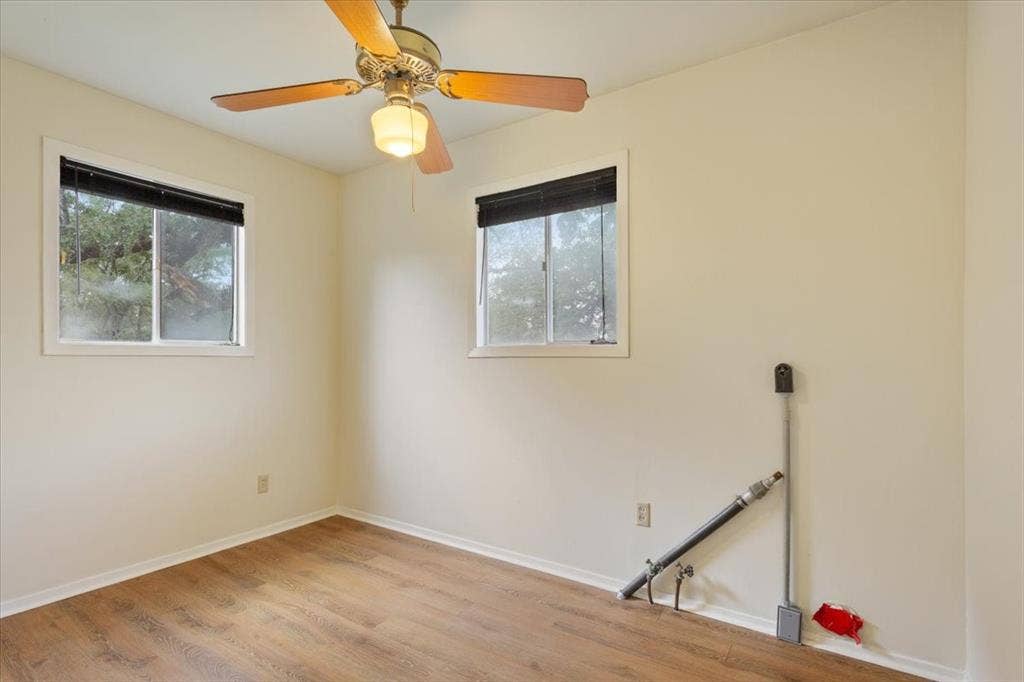 3907 Rogers Hill Road, Waco, TX 76705 Room featuring wood-finish flooring, two sliding windows, and a ceiling fan with integrated lighting