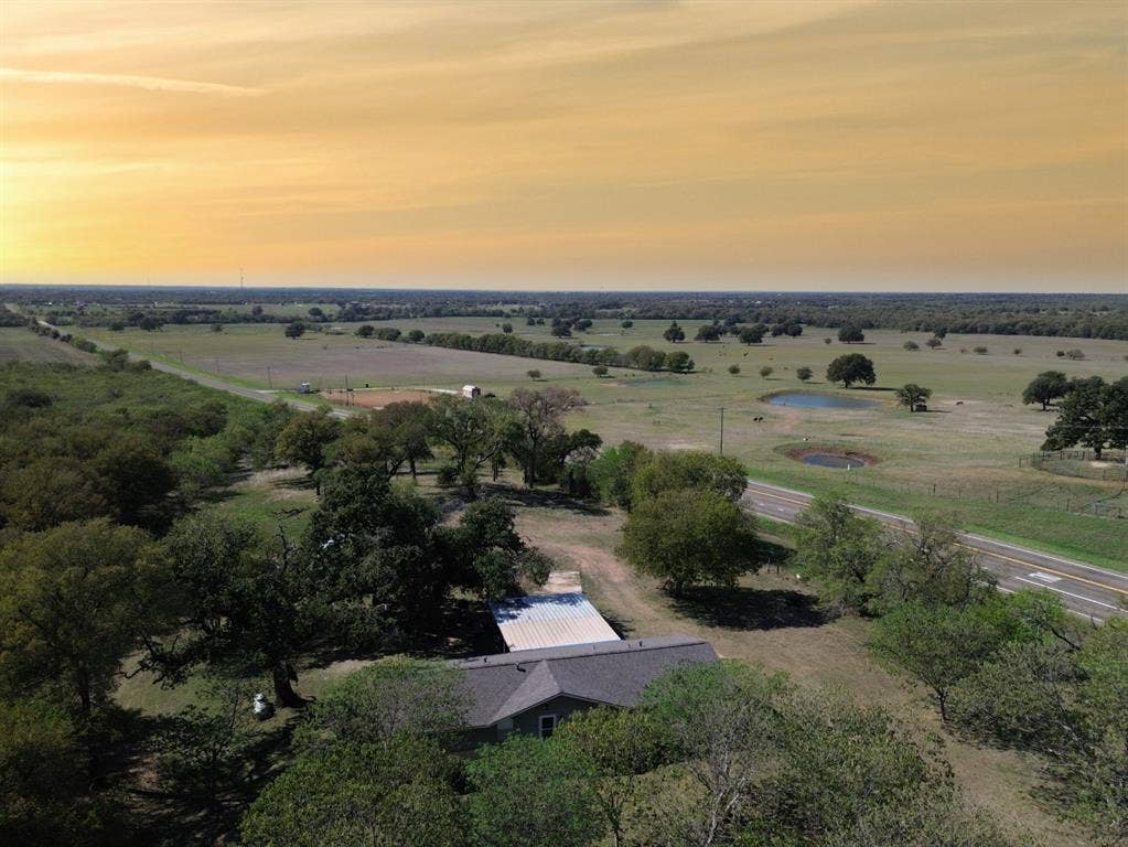 3907 Rogers Hill Road, Waco, TX 76705 Aerial perspective featuring expansive acreage, mature shade trees, and two bodies of water