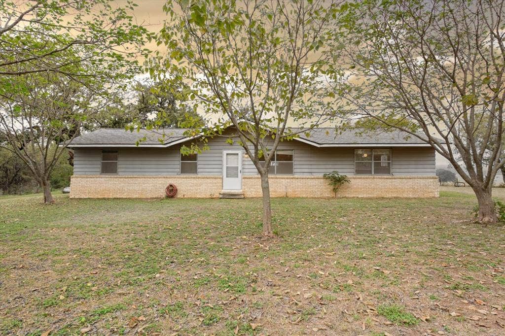3907 Rogers Hill Road, Waco, TX 76705 Single-story residence featuring horizontal siding, a stone veneer base, a gabled roof, and multiple windows