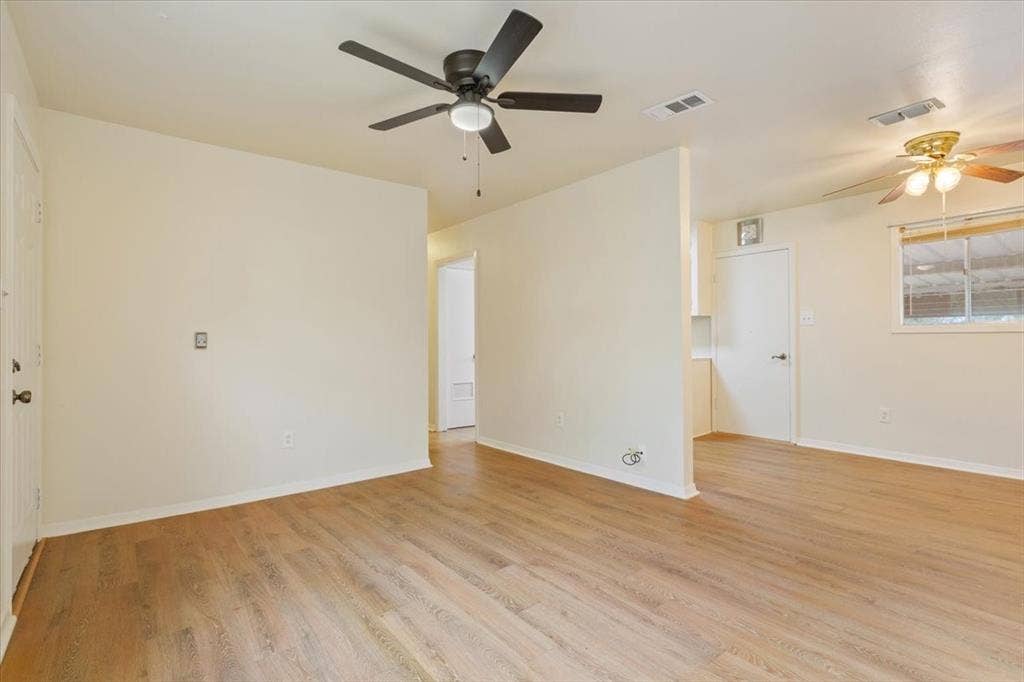 3907 Rogers Hill Road, Waco, TX 76705 Living area featuring wood-finish flooring, two ceiling fans with integrated lighting, and a window with horizontal blinds
