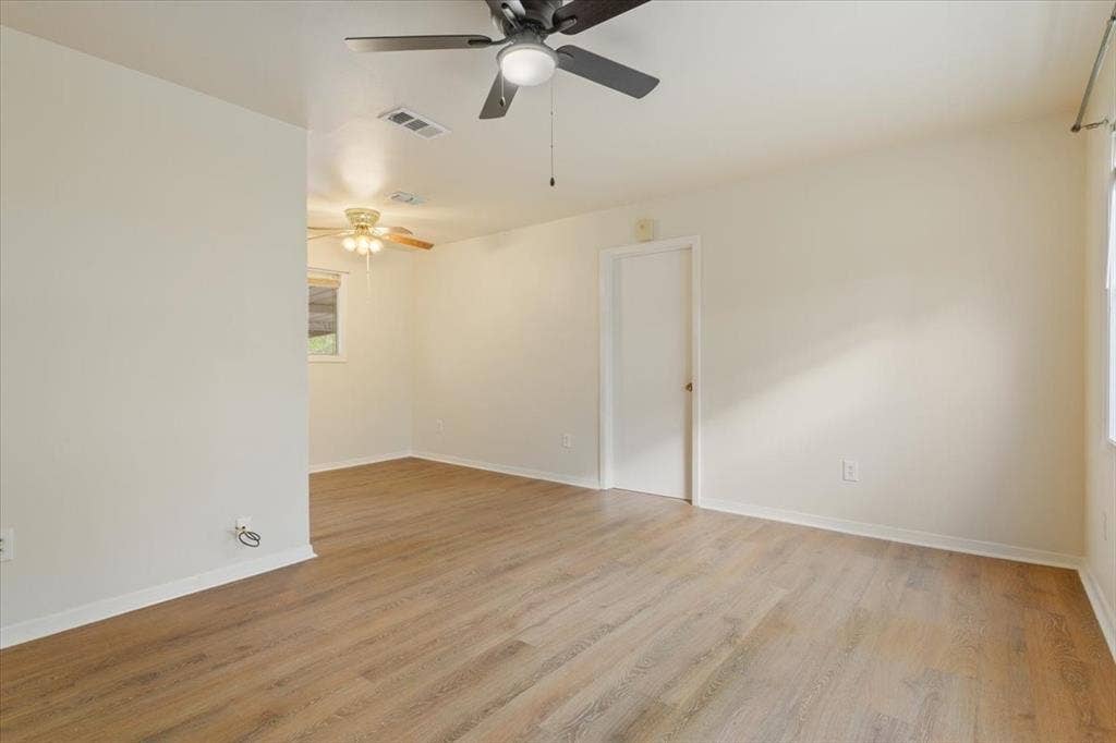 3907 Rogers Hill Road, Waco, TX 76705 Interior space featuring wood-finish flooring, neutral wall tones, and two ceiling-mounted fans with integrated lighting
