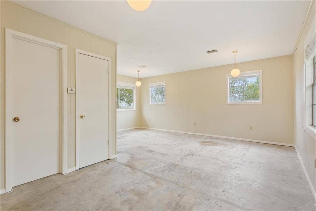 3907 Rogers Hill Road, Waco, TX 76705 Spacious interior featuring neutral wall finishes, multiple windows, and three pendant light fixtures