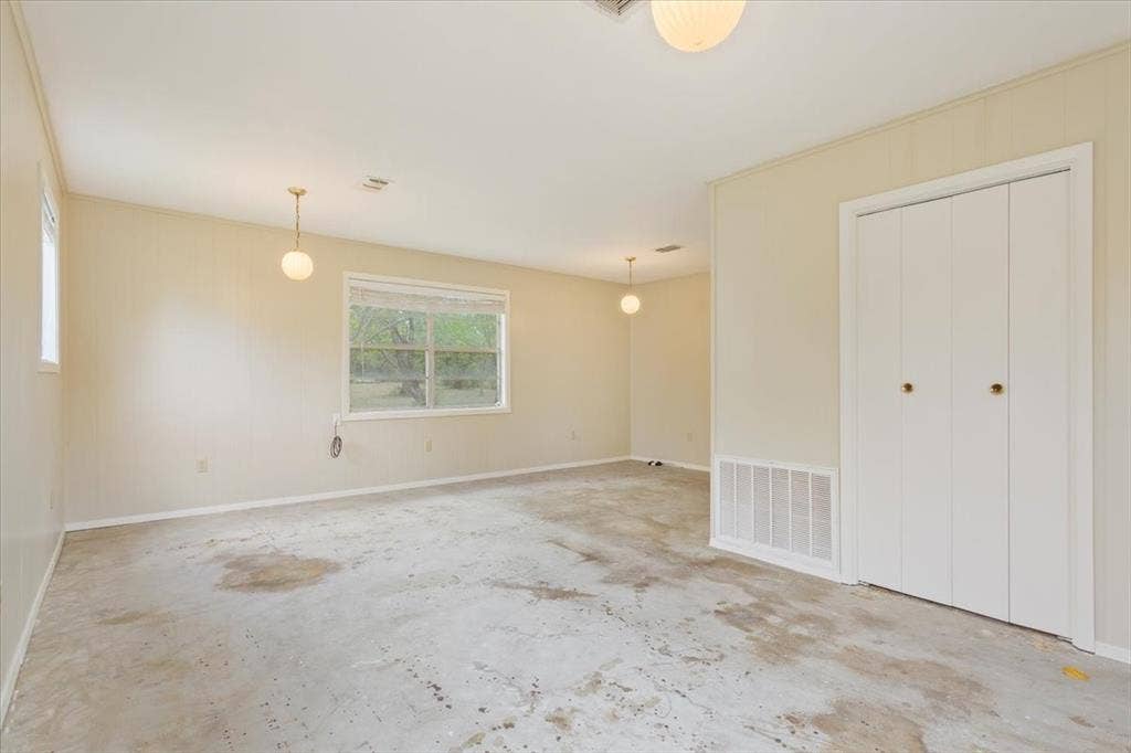 3907 Rogers Hill Road, Waco, TX 76705 Neutral-toned interior featuring multi-panel sliding closet doors, multiple pendant light fixtures, and a dual-pane window