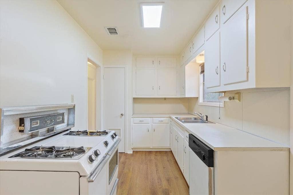3907 Rogers Hill Road, Waco, TX 76705 Kitchen featuring white shaker-style cabinetry, wood-finish flooring, a stainless steel sink, and a four-burner gas range