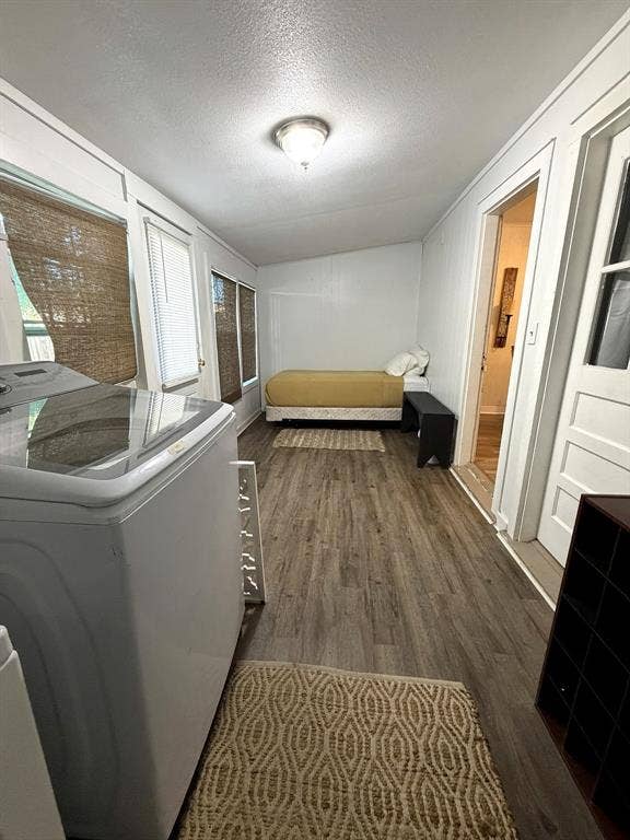 201 S Jones Street, Granbury, TX 76048 Multi-purpose space featuring wood-finish flooring, flush-mount ceiling lighting, multiple windows, and a panel door