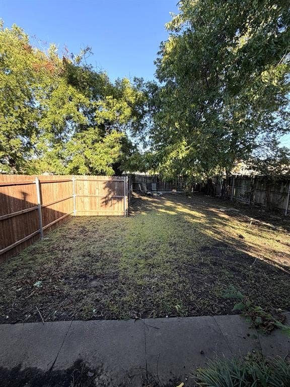 201 S Jones Street, Granbury, TX 76048 Backyard featuring a concrete patio, perimeter wood privacy fencing, and mature trees