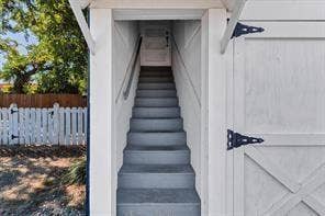 201 S Jones Street, Granbury, TX 76048 Exterior staircase with painted treads, handrail, and white picket fencing