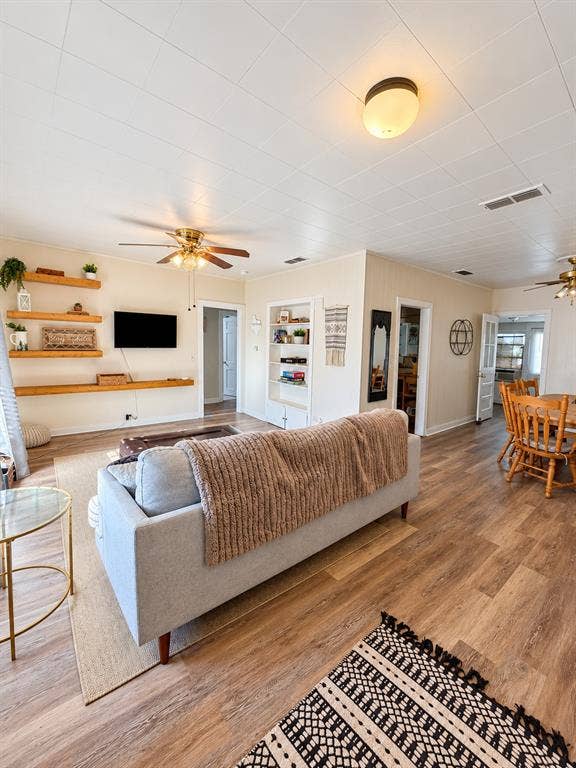 201 S Jones Street, Granbury, TX 76048 Wood-finish flooring, built-in wall shelving, wood-accent floating shelves, and ceiling-mounted light fixtures
