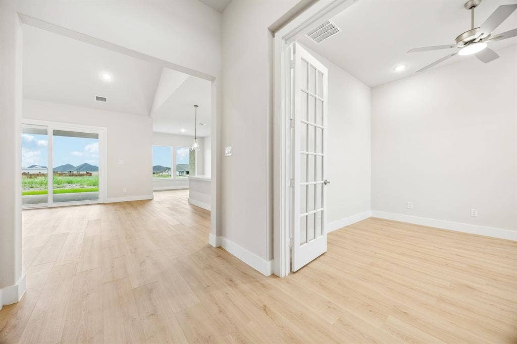 108 Swan Lake Drive, Waxahachie, TX 75165 Wood-finish flooring throughout, French doors with glass panes, ceiling-mounted fan with light fixture, and floor-to-ceiling sliding glass doors