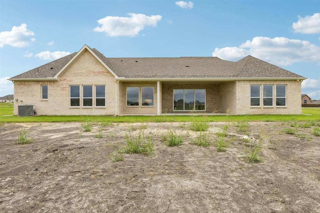 108 Swan Lake Drive, Waxahachie, TX 75165 Single-story brick exterior featuring a multi-gabled roofline, covered rear patio, and expansive grid-pane windows