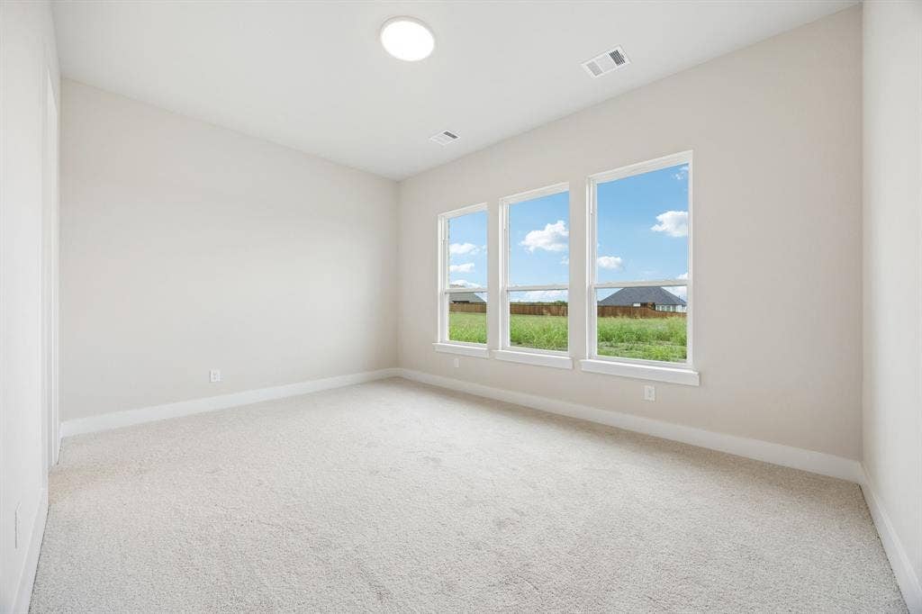 108 Swan Lake Drive, Waxahachie, TX 75165 Neutral-toned interior featuring wall-to-wall carpeting, three windows with exterior landscape exposures, and a recessed ceiling light fixture