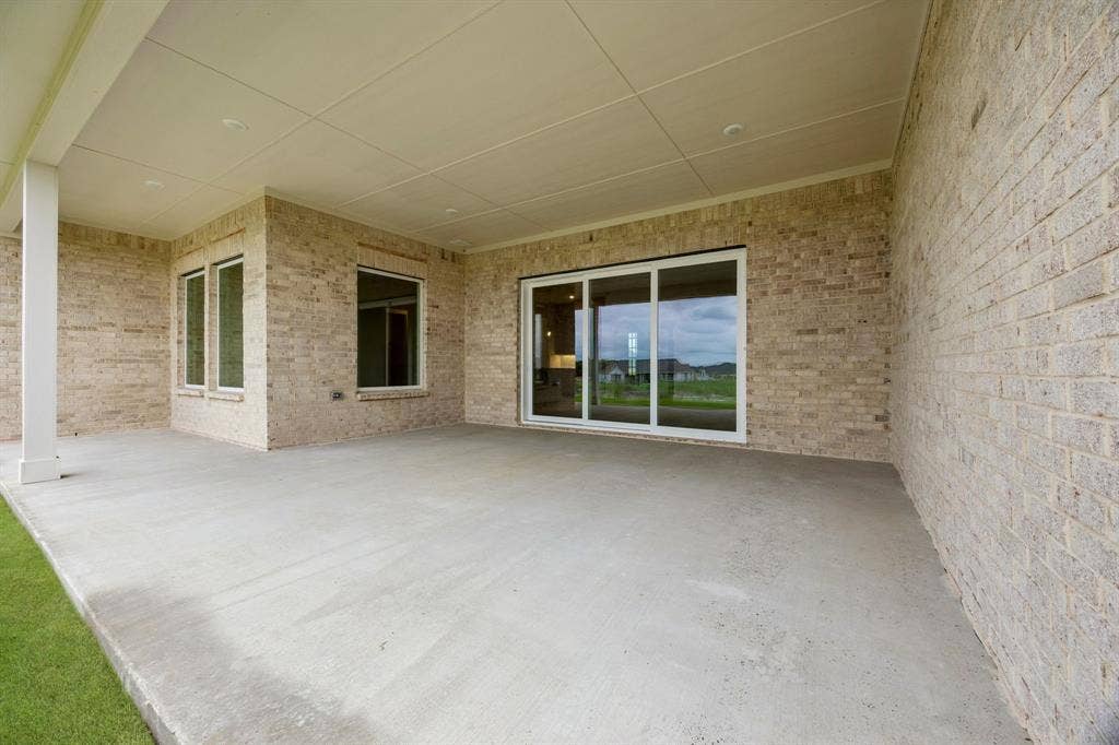 108 Swan Lake Drive, Waxahachie, TX 75165 Covered patio featuring a concrete floor, light-colored brick exterior walls, recessed ceiling lighting, and sliding glass doors