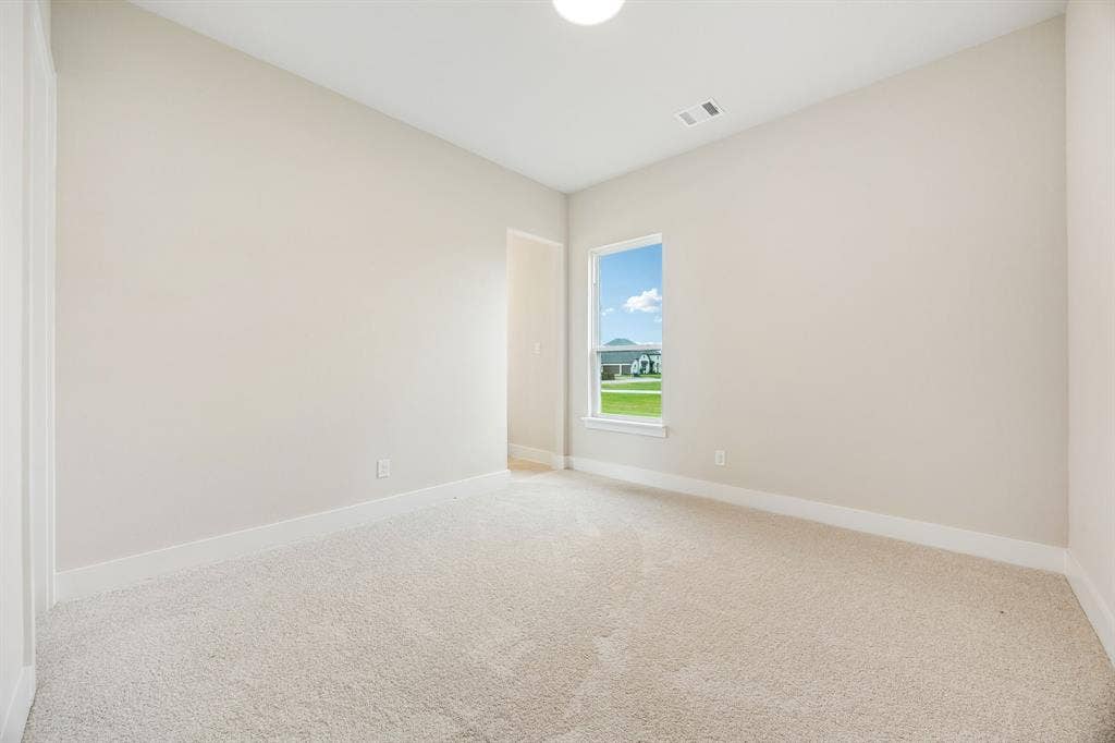 108 Swan Lake Drive, Waxahachie, TX 75165 Neutral-toned room featuring neutral carpeting, crisp white walls, and a single-pane window