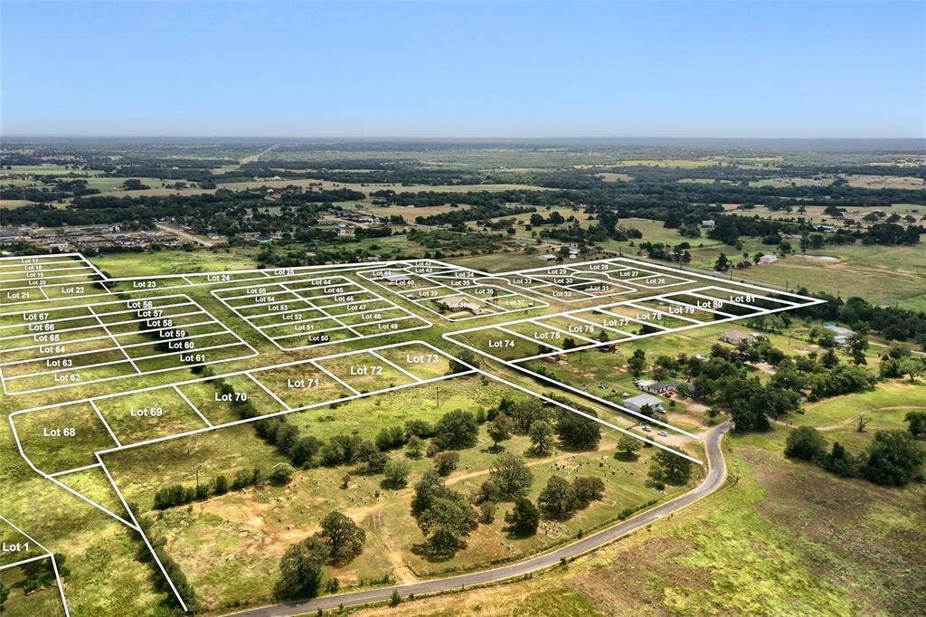 Lot 40 Prado Vista, Elgin, TX 78621 Aerial perspective of expansive residential acreage featuring defined lot boundaries, open terrain, mature trees, and paved thoroughfares