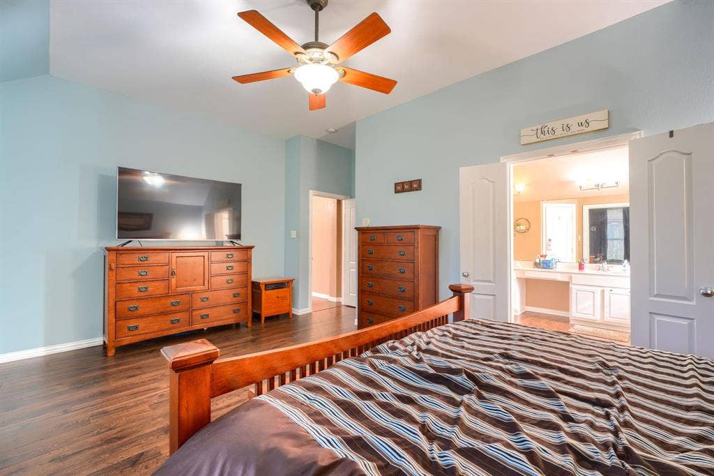 Vaulted ceiling with an integrated wooden-blade ceiling fan, dark wood-finish flooring, and double-door entry