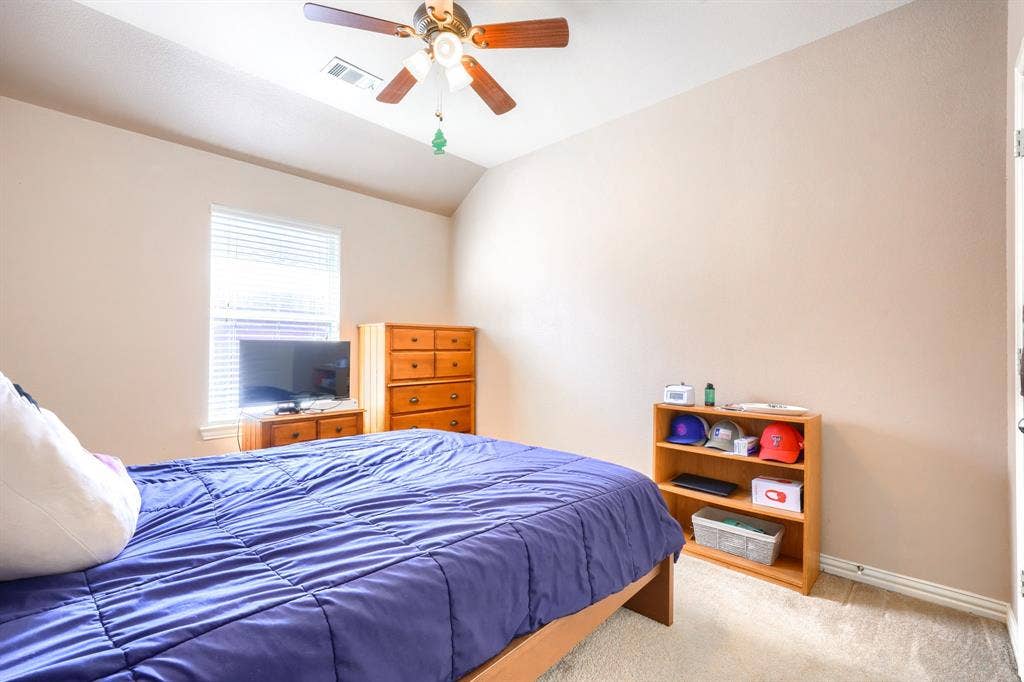 Room featuring neutral-toned walls, high vaulted ceilings, wall-to-wall carpeting, and a ceiling-mounted light fixture with a fan