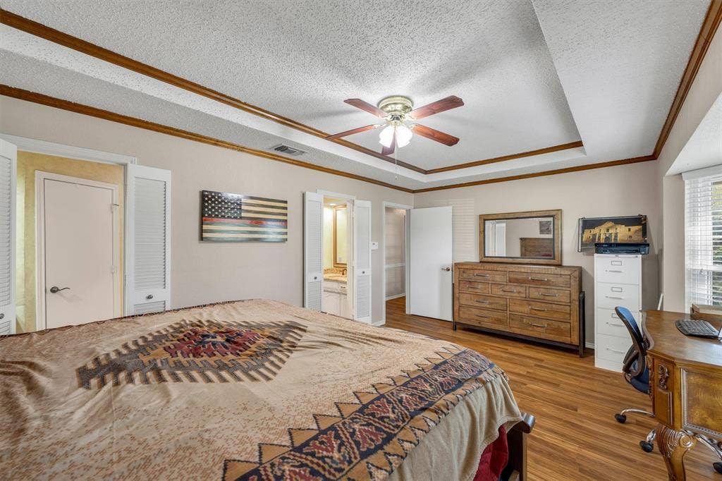 1025 Brownfield Drive, Mesquite, TX 75150 Tray ceiling with wood-trim detailing, wood-finish flooring, and ceiling fan with integrated lighting