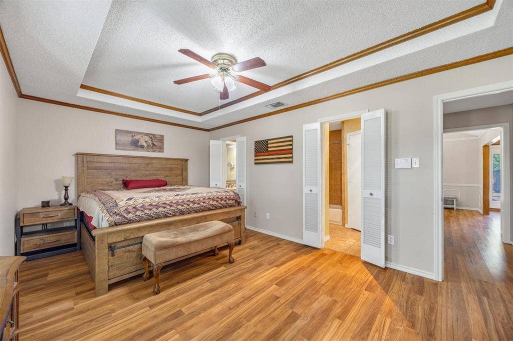 1025 Brownfield Drive, Mesquite, TX 75150 Tray ceiling with crown molding, wood-finish flooring, and integrated ceiling fan