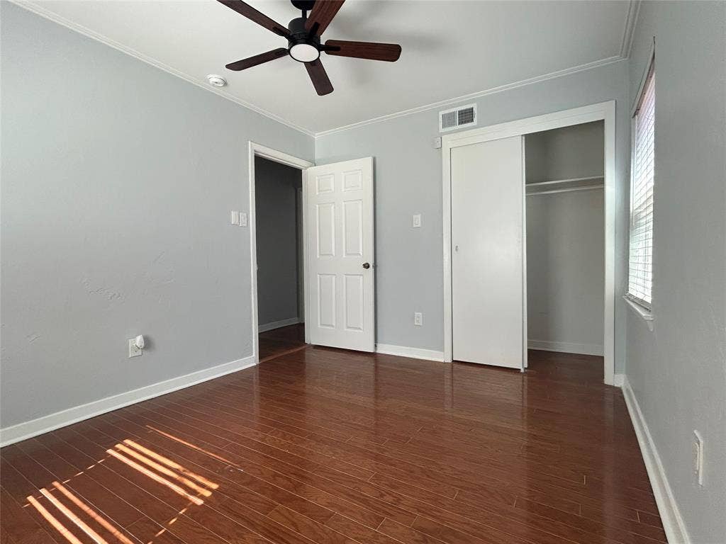3136 Chatsworth Drive, Farmers Branch, TX 75234 Room featuring wood-finish flooring, a ceiling fan with integrated lighting, a sliding-door closet, and a neutral color palette