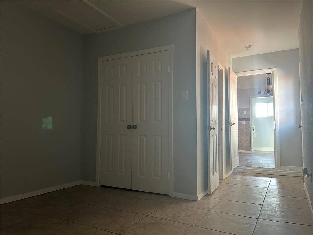 3136 Chatsworth Drive, Farmers Branch, TX 75234 Neutral-toned wall paint, ceramic tile flooring, and white paneled interior doors featuring brushed metal hardware