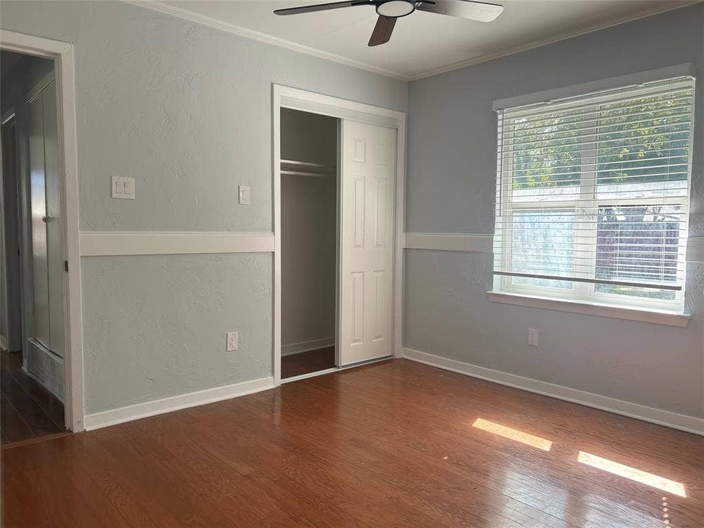 3136 Chatsworth Drive, Farmers Branch, TX 75234 Room featuring wood-finish flooring, chair rail molding, ceiling fan, and sliding closet doors
