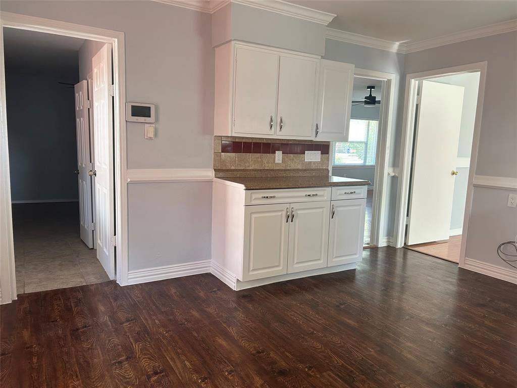 3136 Chatsworth Drive, Farmers Branch, TX 75234 White cabinetry with brushed nickel hardware, stone-finish countertops, tiled backsplash, and dark wood-finish flooring