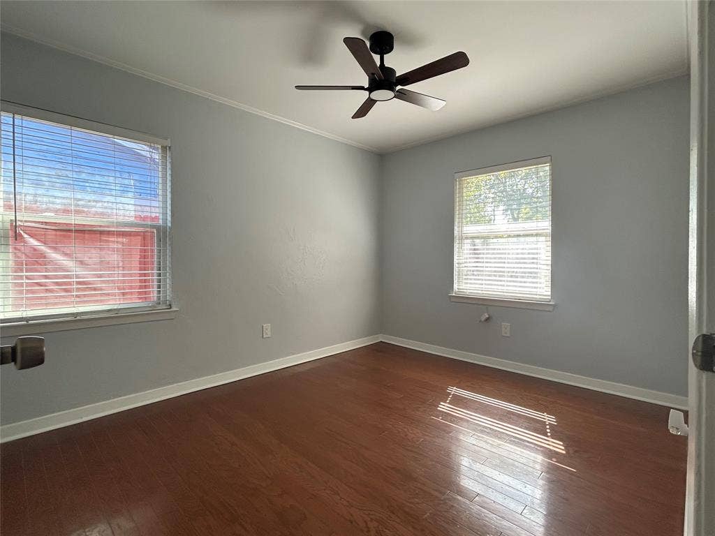 3136 Chatsworth Drive, Farmers Branch, TX 75234 Room featuring wood-finish flooring, two windows with horizontal blinds, and a black ceiling fan with integrated lighting