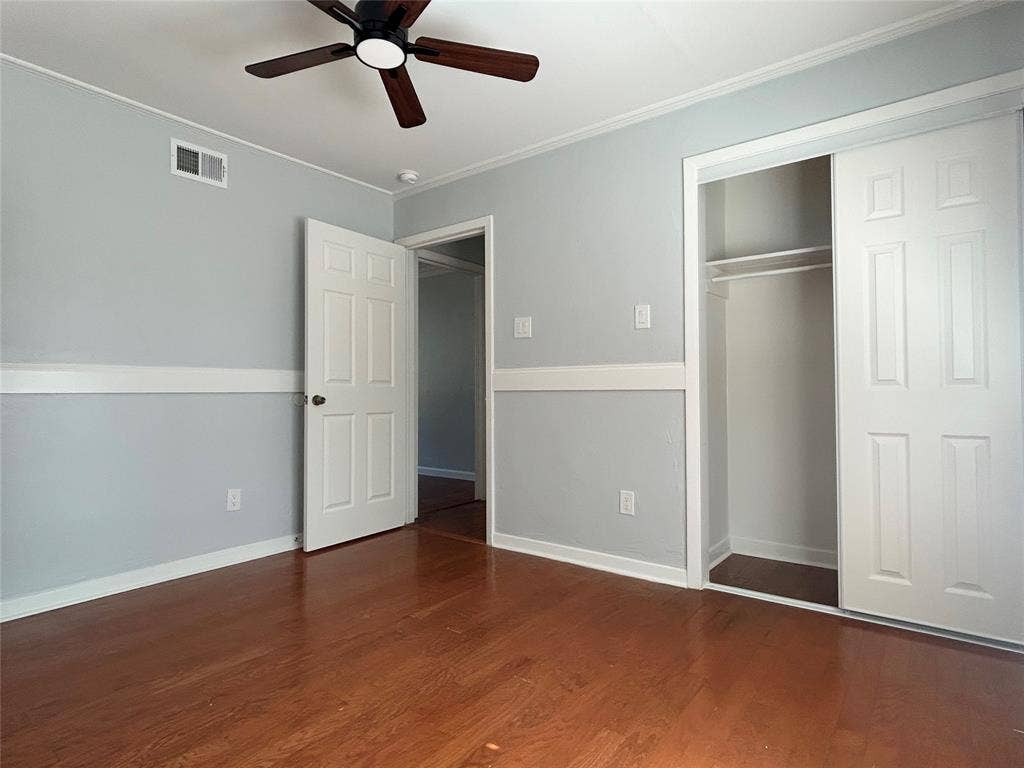3136 Chatsworth Drive, Farmers Branch, TX 75234 Wood-finish flooring, chair rail molding, ceiling fan with integrated lighting, and built-in closet with sliding doors