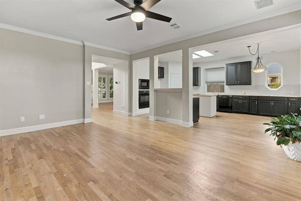 511 Clover Leaf Lane, McKinney, TX 75072 Open-concept area featuring wood-finish flooring, a matte black ceiling fan, recessed lighting, and kitchen cabinetry with dark finishes