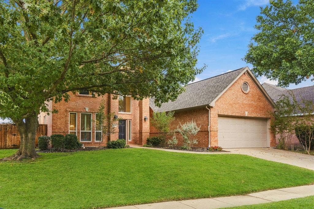 511 Clover Leaf Lane, McKinney, TX 75072 Brick exterior featuring a multi-gabled roofline, an integrated two-car garage, large vertical windows, and a circular accent window