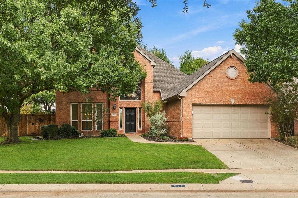 511 Clover Leaf Lane, McKinney, TX 75072 Two-story brick exterior featuring a multi-gabled roofline, an attached two-car garage, and mature landscaping