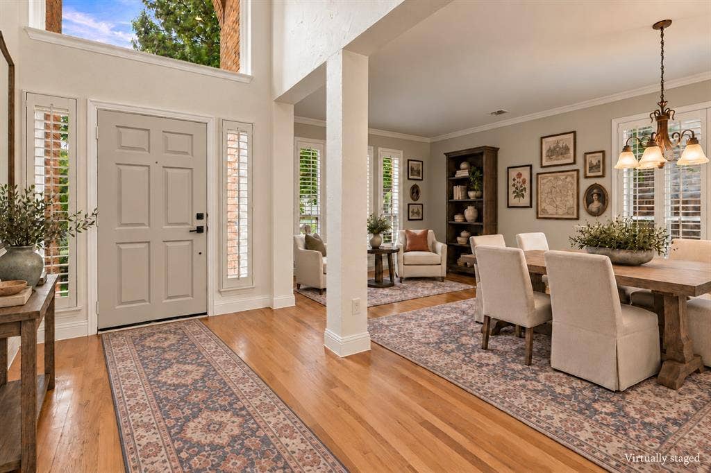 511 Clover Leaf Lane, McKinney, TX 75072 Entryway featuring double-height ceilings, wood-finish flooring, plantation shutters, and a multi-light chandelier