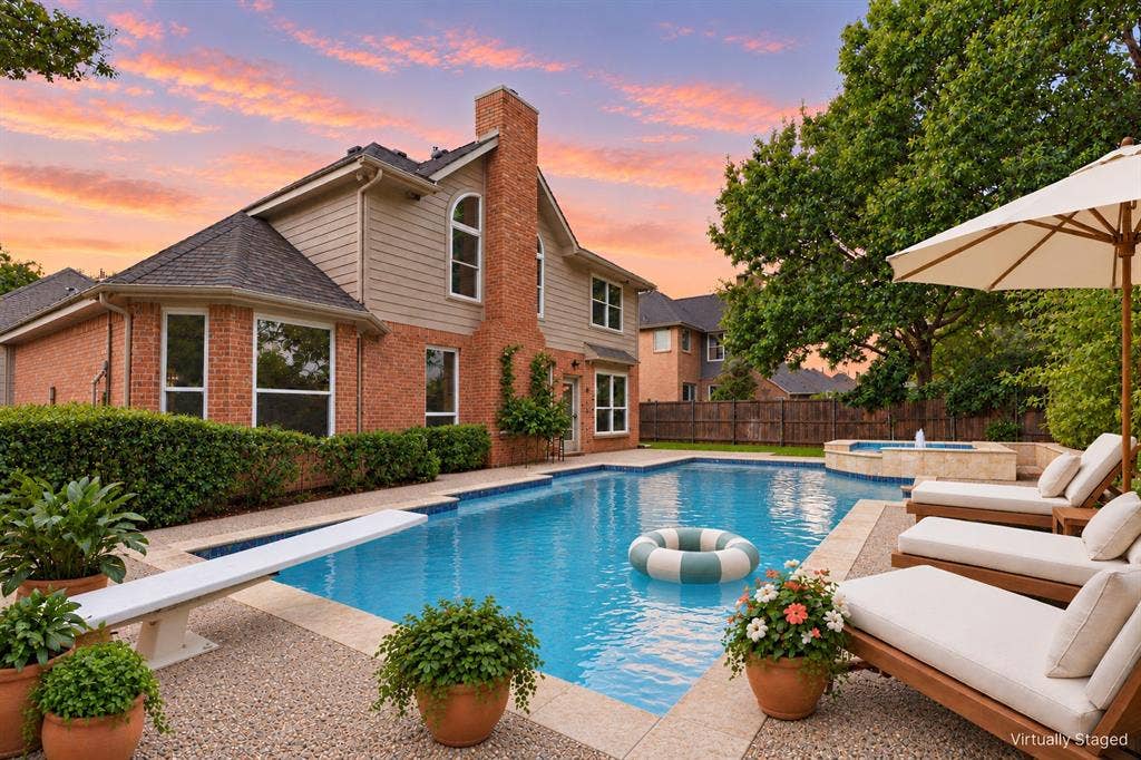 511 Clover Leaf Lane, McKinney, TX 75072 Brick and horizontal siding exterior featuring a multi-story chimney, a swimming pool with a diving board, and an integrated spa