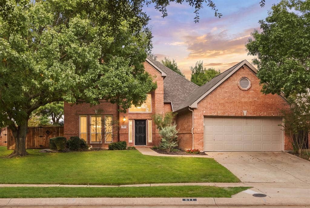 511 Clover Leaf Lane, McKinney, TX 75072 Traditional brick exterior featuring a multi-gabled roofline, an attached two-car garage, mature trees, and a front lawn